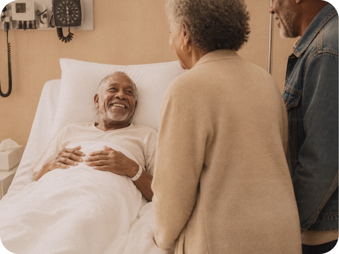 A patient at home with a visiting family member and a care worker